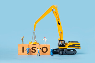 The word ISO is written on a wooden box, miniature people and excavator trucks make up the box.
