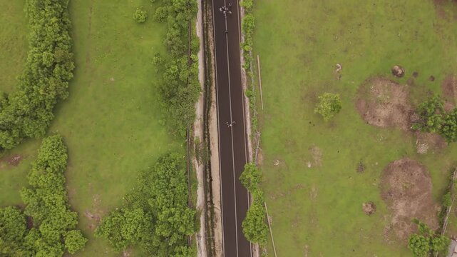 Top-Down Aerial Ascending Flight Reveals Narrow Road Cutting Through Valley at Tanah Barak, Bali Indonesia