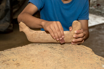 Hands sanding a piece of wood in a workshop. Artisanal process using sandpaper, meticulous...