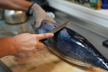 魚を捌く男性の手