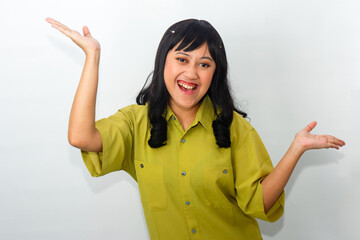 An enthusiastic Asian woman wearing a green shirt with a laughing face, pointing upwards to...