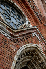 Architectural styles of the Catholic Church, view from below. Fragment of the decoration of the church in the neo-Gothic style. Roman Catholic church made of brick in the neo-Gothic style