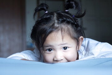 Sleepless little girl after playing in bed.