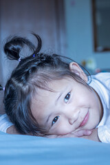 Sleepless little girl after playing in bed.