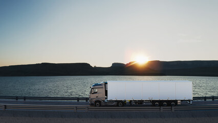 Industrial logistics truck driving on coastal highway at sunset.. © phaisarnwong2517