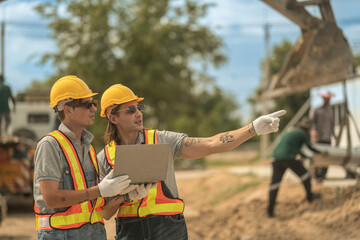 Construction professionals in safety gear reviewing plans at a construction site, showcasing teamwork, engineering precision, and on-site project management for infrastructure development.