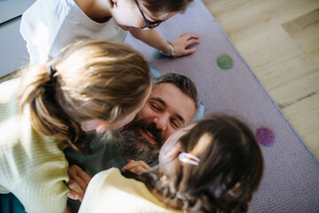 Portrait of father with three daughters at home.