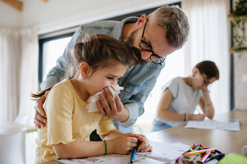 Father helping his daughter blow congested nose.