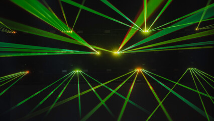 Green laser lights illuminating dark concert hall during music show