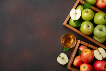 Ripe red and green apples in wooden box on a rusty background