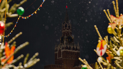 Snow falling on Spasskaya Tower during christmas night in Moscow