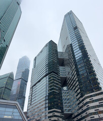 A city skyline with tall buildings and a cloudy sky