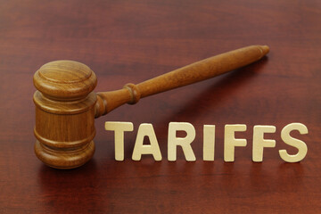 Tariffs and import rules concept. Word tariffs and judge gavel close-up.