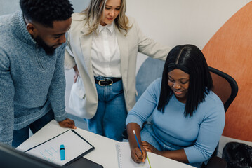 Managers helping employee with a task in the office