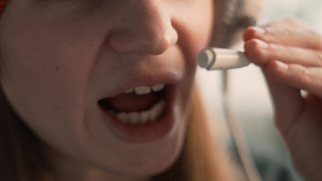 Smiling girl chats with loved ones using wireless headset, enjoying friendly talk in familiar environment. Emotion and comfort visible in close-up shot of her speaking.