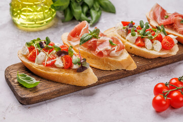 Tasty antipasto toasts featuring classic caprese with mozzarella and tomatoes, and savory prosciutto with herbs