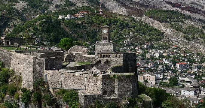 View of Gjirokast&euml;r Castle&rsquo;s historic walls with the charming stone-built village and huge mountains behind.
