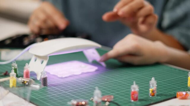 Interactive experiment with epoxy resin as child explores curing process under UV lamp. Parent supervises, ensuring fun and educational experience in safe home environment.