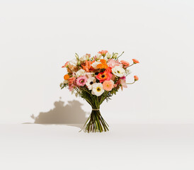 Fototapeta premium Bright and vibrant mixed flower bouquet featuring pink, orange, and white blooms arranged artistically on a soft background, ideal for gifting or decoration