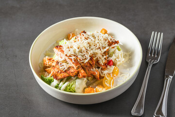 Top view of chicken caesar salad on grey stone table