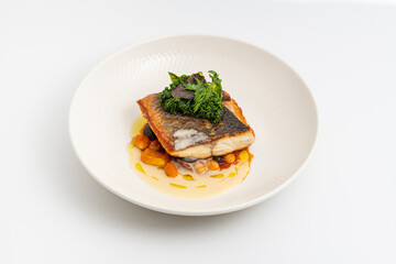 Crispy-skinned pan-seared fish fillet with chickpeas, creamy sauce, and fresh greens