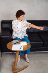 Monitoring blood pressure at home during a health checkup in the living room.