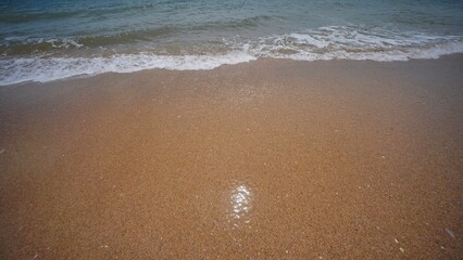 Gentle waves washing golden sand on Crimean beach