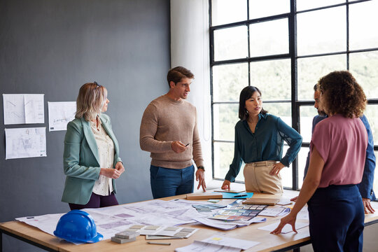 Architects and engineers discussing project on blueprint during a brief