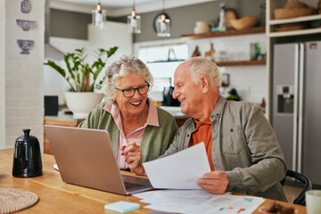 Happy old couple managing home finances on laptop