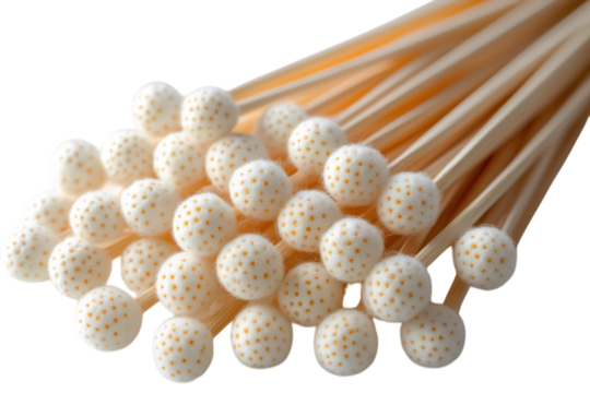 Wide assortment of wooden skewers featuring white tips with orange dots on a neutral background