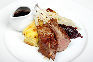 Roasted lamb with potatoes and rich sauce on plate