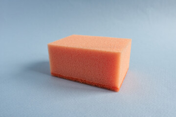 Orange sponges for washing dishes on a gray background. Close-up.