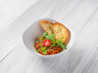 Hot appetizer from fried eggplant and tomatoes with fresh cilantro