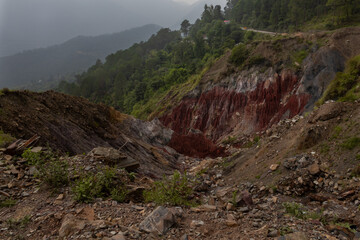 A striking view of red rock formations sculpted by monsoon erosion in the natural hills of Himachal Pradesh, India.