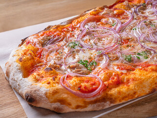 Pizza Cipolla. Italian pizza from a stove with tomato sauce red onions and Mozarella. Pizza on a wooden board