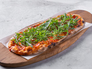 Classic Margherita pizza with a thin, crispy crust, rich tomato sauce, melted mozzarella, and fresh basil leaves. Served on a rustic wooden board with a warm, textured background, emphasizing its