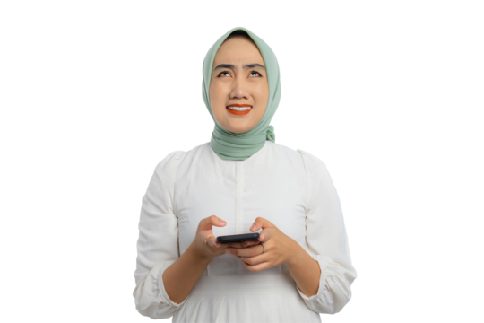 Sad young Asian woman in green hijab and white blouse pressing her finger on mobile phone and looking upward isolated on transparent background