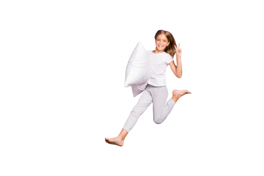 Full length photo of positive cheerful cute blonde hair kid jump hold pillow enjoy weekend sleep-over party make v-signs wear white t-shirt pants isolated over purple violet color background