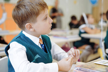 cute little boy sittimg at the class in school