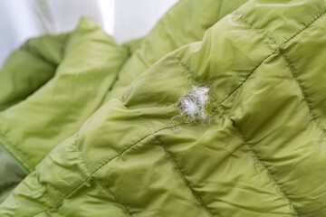 破れて羽毛が飛び出しているダウンジャケット