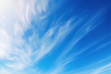 Abstract blue sky with soft white clouds in a bright atmosphere.