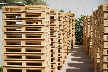Stacks of Wooden Pallets Vertical Arranged Outdoors in Industrial Factory Setting