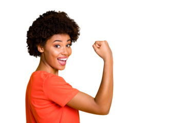 Copyspace photo of excited casual ecstatic curly wavy overjoyed girlfriend american showing her biceps rejoicing her physical condition wearing orange t-shirt isolated vivid color yellow background