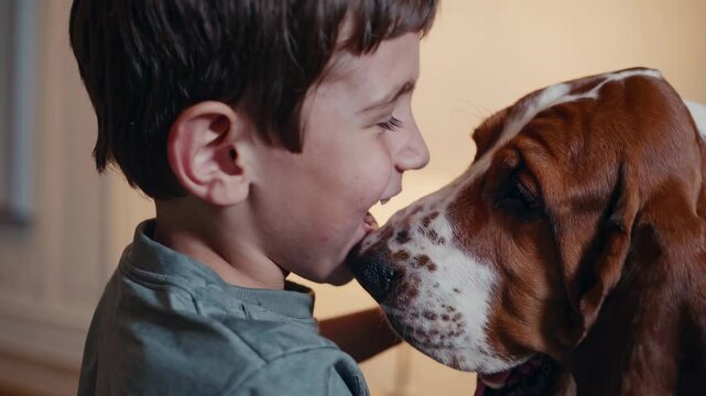 Laughing boy with freckles and basset hound dog sharing joyful moment