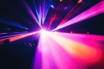 Vibrant laser beams illuminate a dark concert venue, creating a mesmerizing spectacle for the audience.