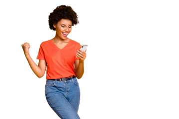 Copyspace photo of fashionable stylish trendy cheerful champion curly wavy having received feedback looking at phone screen wearing jeans denim orange t-shirt isolated yellow vivid color background