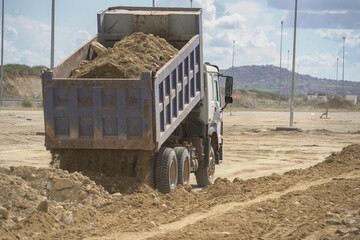 Dump Truck and Grader Operating Together on Dirt Road Project