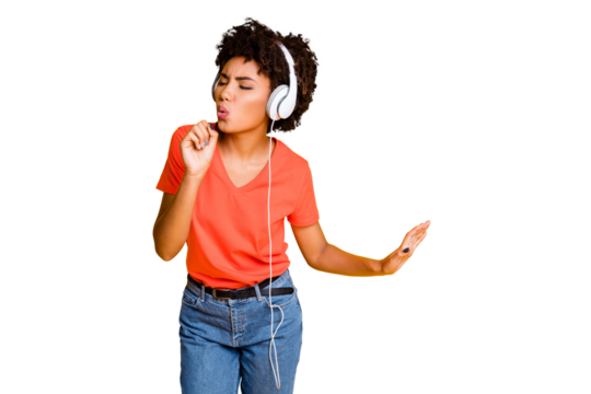 Photo of cheerful charming attractive nice cute curly wavy trendy black afro american girlfriend wearing jeans denim t-shirt singing wearing headphones isolated bright color yellow background