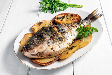 Orata al forno con patate, cibo mediterraneo 