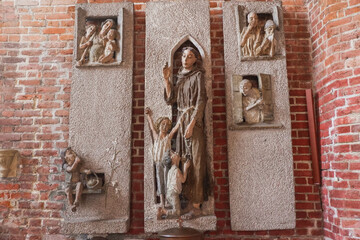 Religious Relief Sculpture Inside St. Mary's Church. Close-up of a detailed religious relief sculpture on a brick wall
